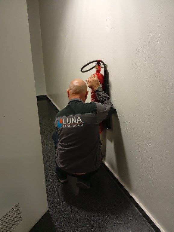 Profesional de Luna Grupo instalando un extintor